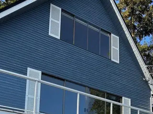 Even, deep blue paint on horizontal siding with fresh white shutters, after the job