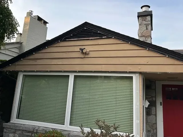 House exterior before repainting, with tan siding and a red front door