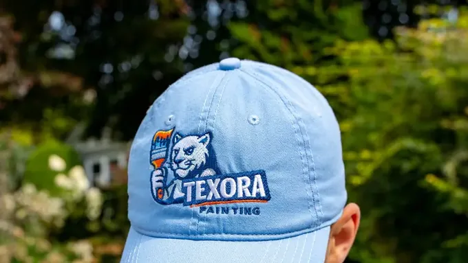 Texora Painting branded cap worn during a garage door painting job