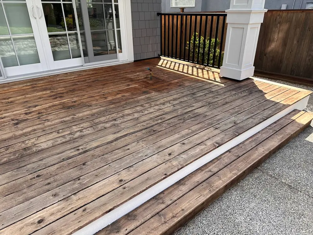 Deck after chemical strip — boards stripped clean before new stain applied