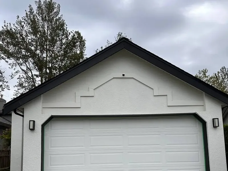 White sectional garage door set in white stucco before repainting